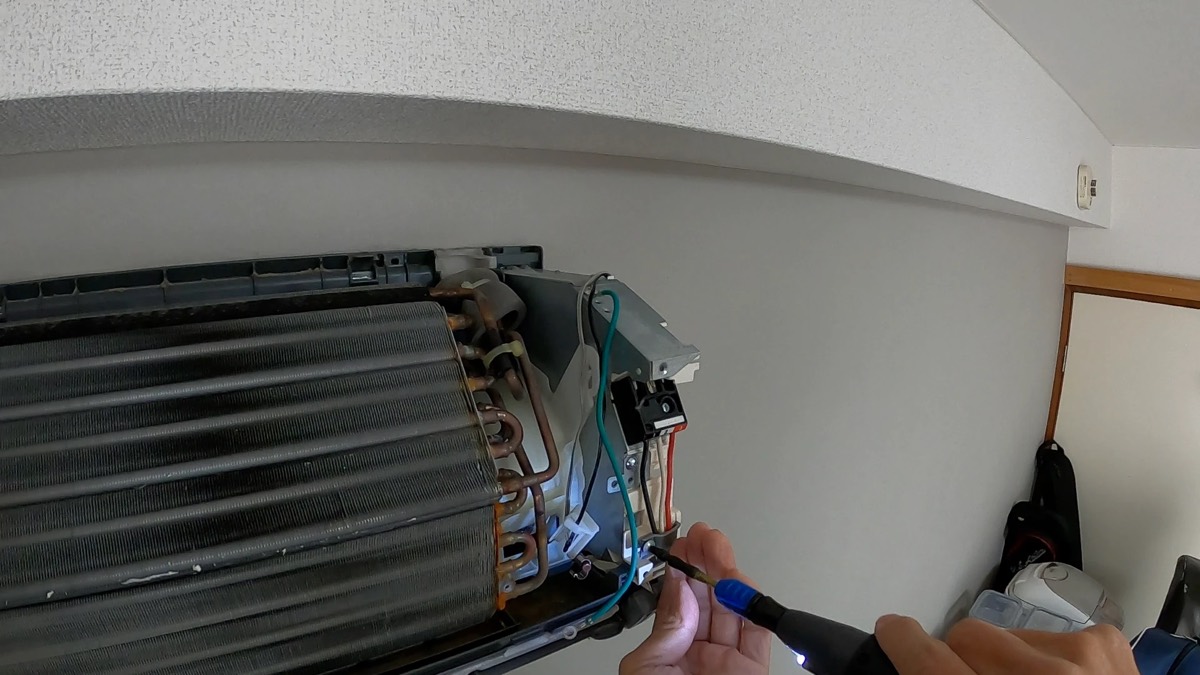 エアコンを分解し、内部の熱交換器を露出させて作業しているところ